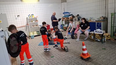 Bild vergr&ouml;&szlig;ern: Die Gruppe der Stufe 1 bei der Versorgung einer verletzten Person mit einer vermutlich gebrochenen Hand